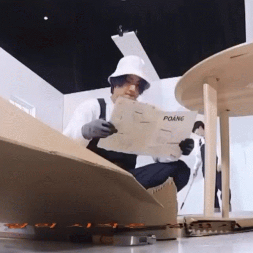 Man in White Hat Reading Newspaper Titled Poang
