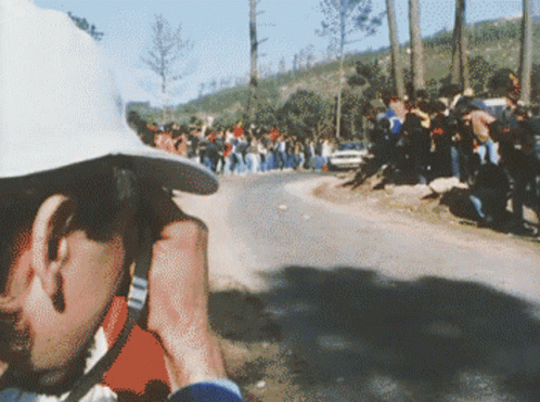 Man in White Hat Taking Photo of Race
