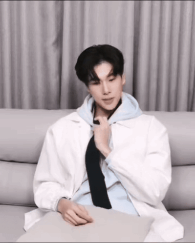 Man in White Jacket and Black Tie on Couch