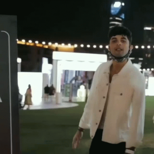 Man in White Jacket and Mask at Night