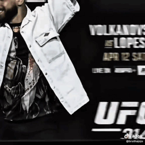 Man in White Jacket in Front of UFC Sign