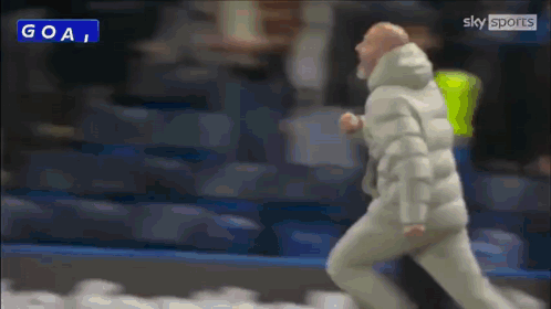 Man In White Jacket Running Past Goal Sign GIF