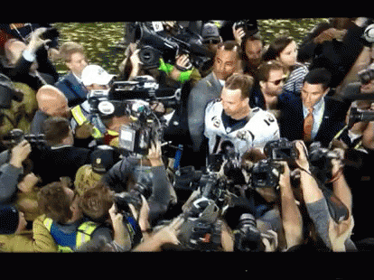 Man in White Jersey Surrounded by Crowd Taking Pictures