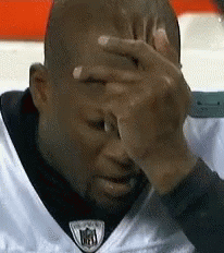 Man in White NFL Jersey Covering Face