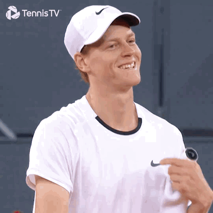 Man in White Nike Hat Smiling Holding Tennis Racquet