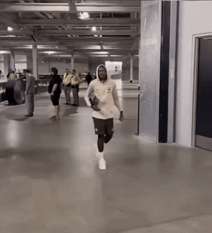 Man In White Nike Sweatshirt Running In Hallway GIF