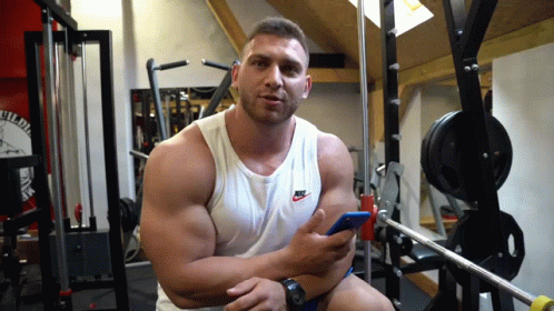 Man In White Nike Tank Top Holding Cell Phone GIF