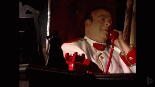 Man in White Red Uniform Talking on Red Phone 19