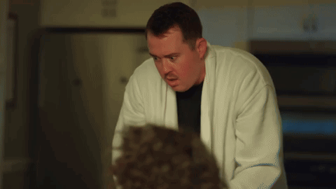 Man In White Robe Looking At Man In Black Shirt GIF