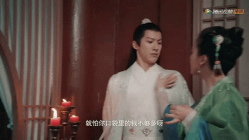 Man In White Robe Next To Woman In Green GIF