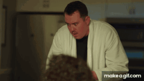 Man In White Robe Standing In Front Of Microwave GIF