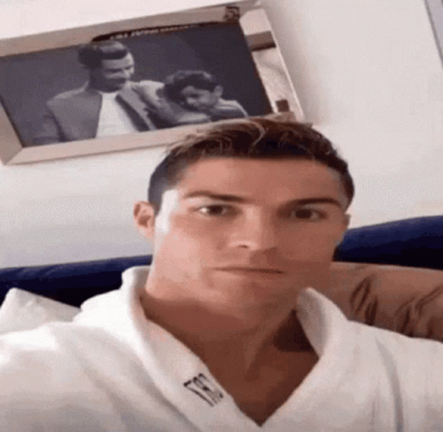 Man in White Robe Taking Selfie with Framed Couple