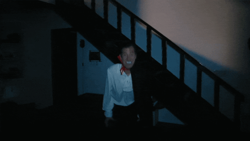 Man in White Shirt and Black Cape Walking Down Stairs