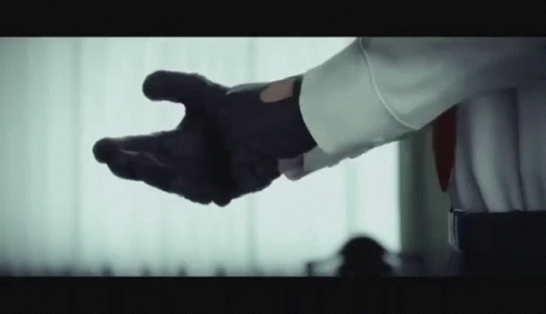 Man in White Shirt and Black Gloves Reaching