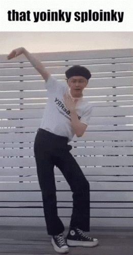 Man in White Shirt and Black Pants Dancing in Front of Fence Saying That Yoinky Sploinky