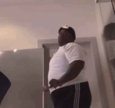 Man in White Shirt and Black Pants Standing in Front of Door