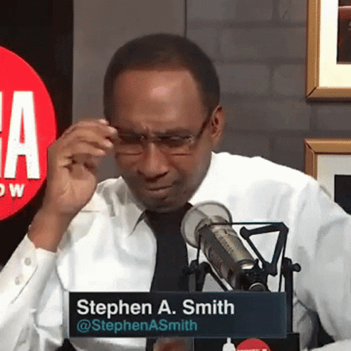 Man in White Shirt and Black Tie at Microphone with Stephen A. Sign