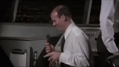 Man in White Shirt and Black Tie Holding Microphone