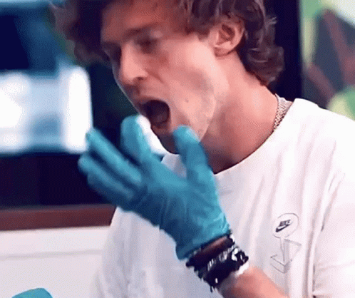 Man in White Shirt and Blue Gloves Eating