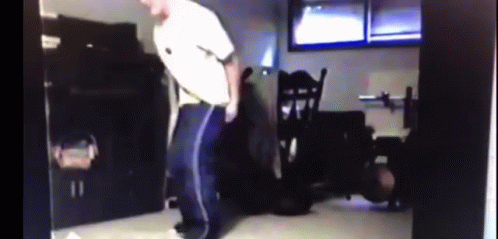 Man In White Shirt And Blue Pants Dancing In Dark Room GIF