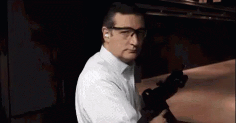 Man in White Shirt and Glasses Holding Gun