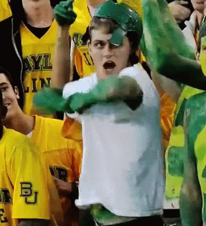Man in White Shirt and Green Gloves Standing Before Crowd