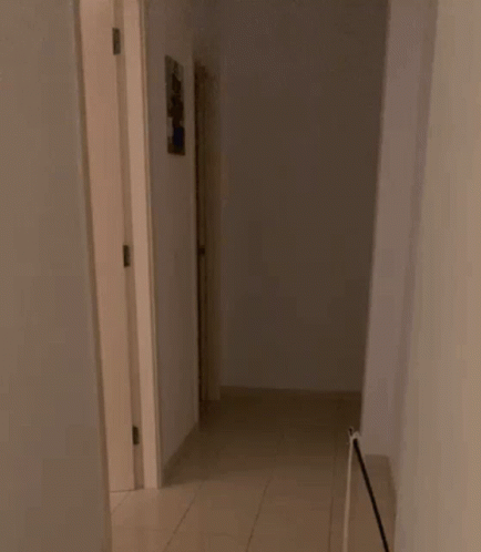 Man In White Shirt And Necklace By Bookshelf GIF