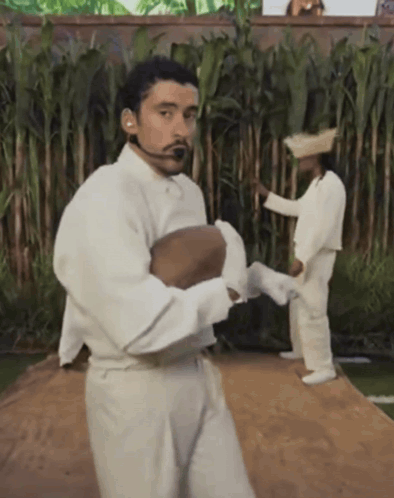 Man in White Shirt and Pants Holding Ball