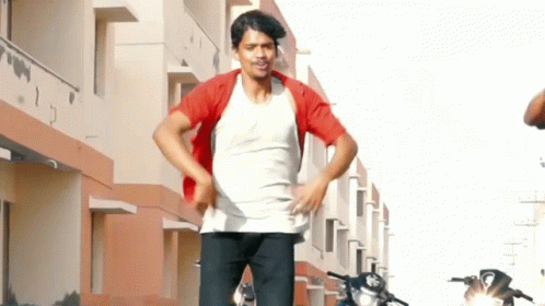 Man In White Shirt And Red Jacket Standing In Front Of Building GIF