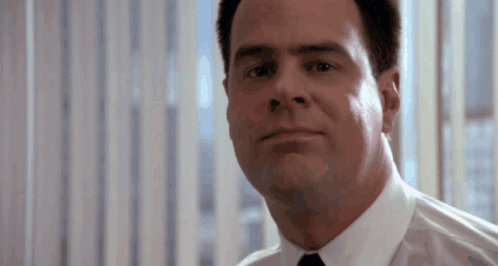 Man in White Shirt and Tie Looks at Camera