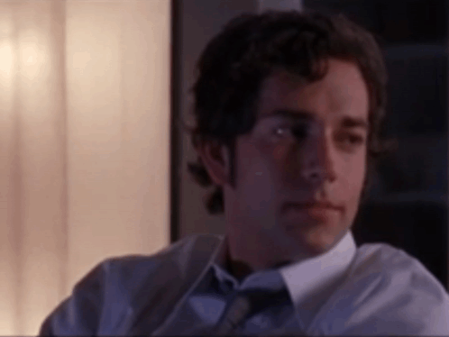 Man in White Shirt and Tie Sitting in Dark Room