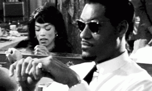 Man In White Shirt And Tie Sitting In Front Of Mirror While Woman Looks At Him GIF