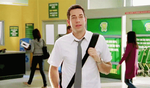 Man in White Shirt and Tie Walking Through Store