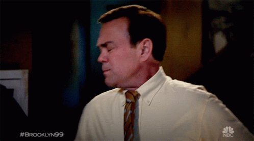 Man in White Shirt and Tie with NBC Logo