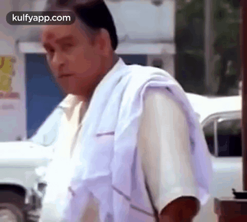 Man in White Shirt and Towel Beside White Car