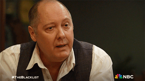 Man In White Shirt And Vest In Front Of NBC Logo GIF