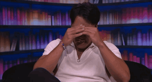 Man in White Shirt Covering Eyes