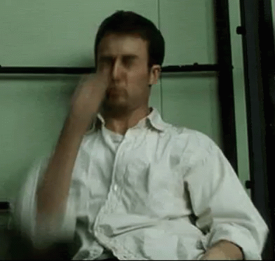 Man in White Shirt Covering Nose