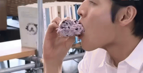 Man in White Shirt Eating Doughnut
