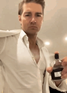 Man in White Shirt Holding Bottle of Perfume
