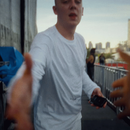 Man in White Shirt Holding Cell Phone