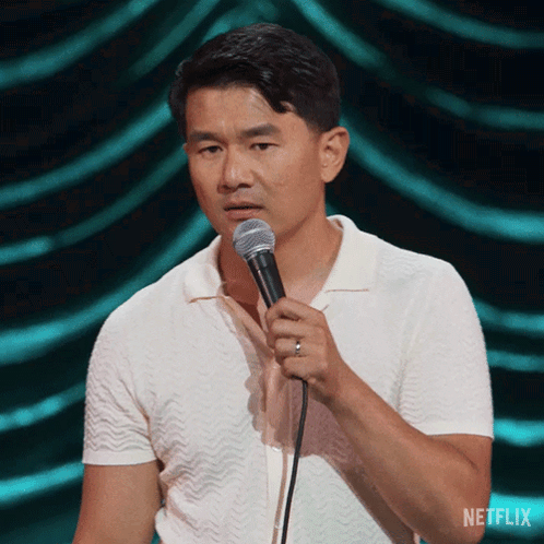 Man in White Shirt Holding Microphone with Netflix Logo