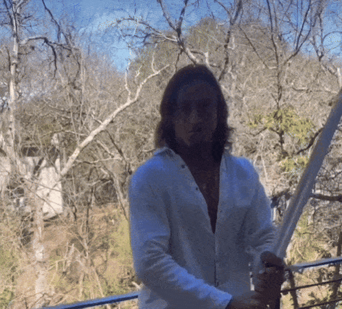 Man In White Shirt Holding Sword In Forest GIF