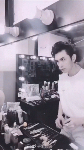 Man in White Shirt Looking at Mirror in Dressing Room