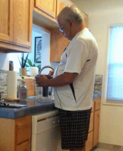 Man in White Shirt Looking at Phone