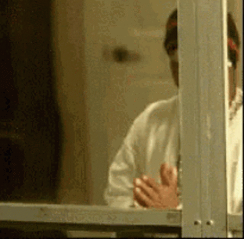 Man in White Shirt Looking Out Window