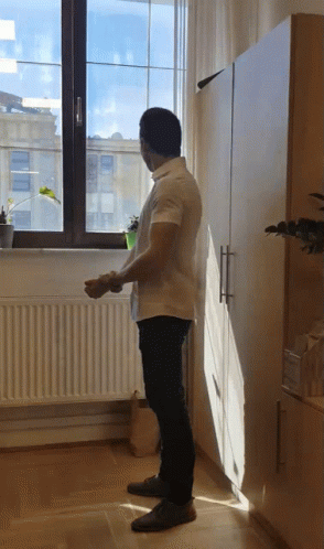 Man In White Shirt Looking Out Window GIF