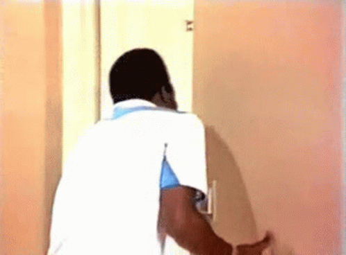Man In White Shirt Looking Through Door GIF