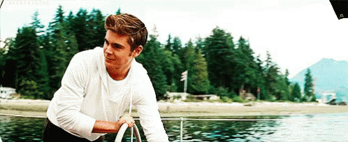 Man in White Shirt on Boat in Water