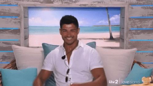 Man in White Shirt on Couch with Beach Picture